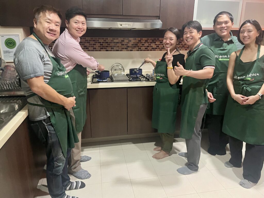 Hands-on vegan cooking class students preparing Indian cuisine in Singapore