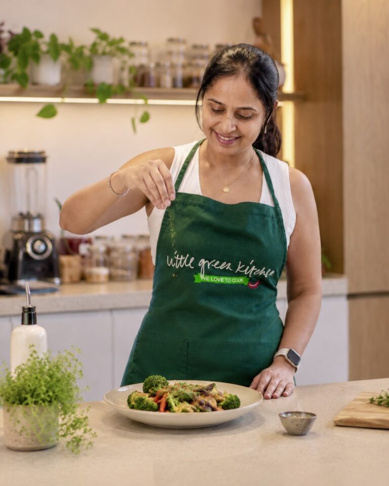 Chef Shalu of Little Green Kitchen plating a vegan vegetable stir-fry in her Singapore kitchen